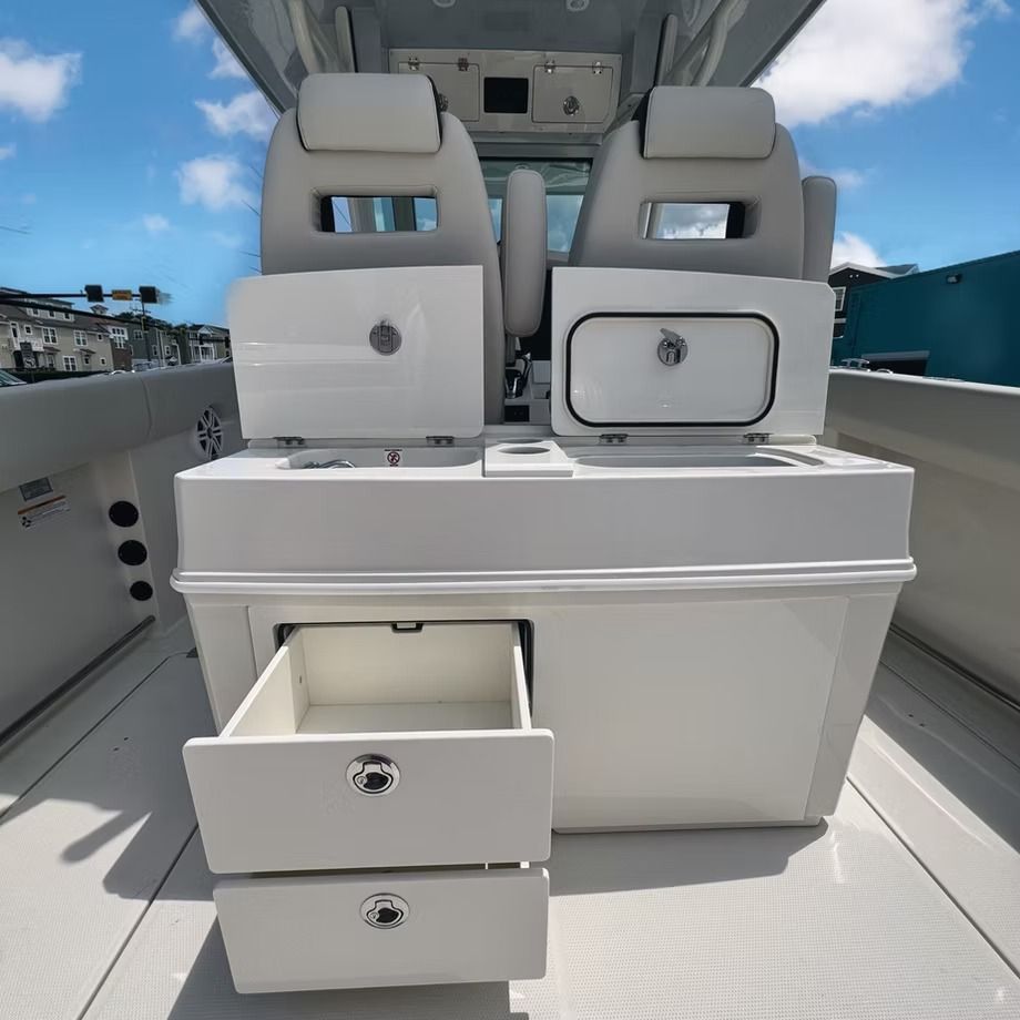 White boat console with two seats, storage compartments, and open drawers.