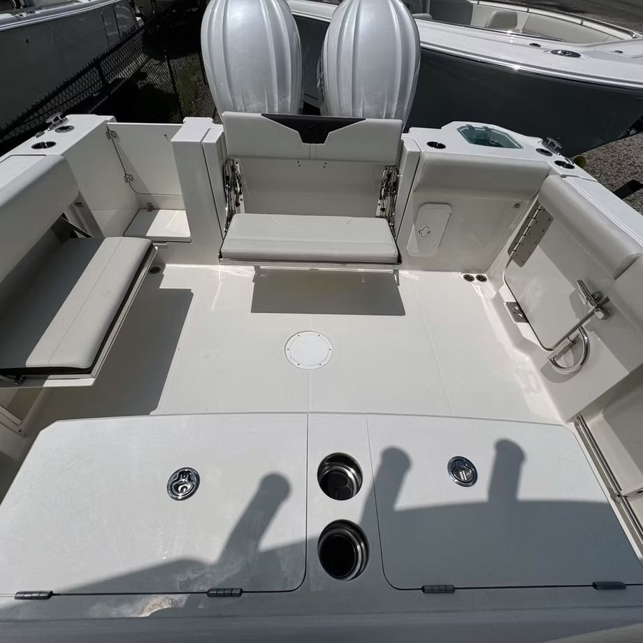 White boat deck with two outboard motors, seating, and storage.