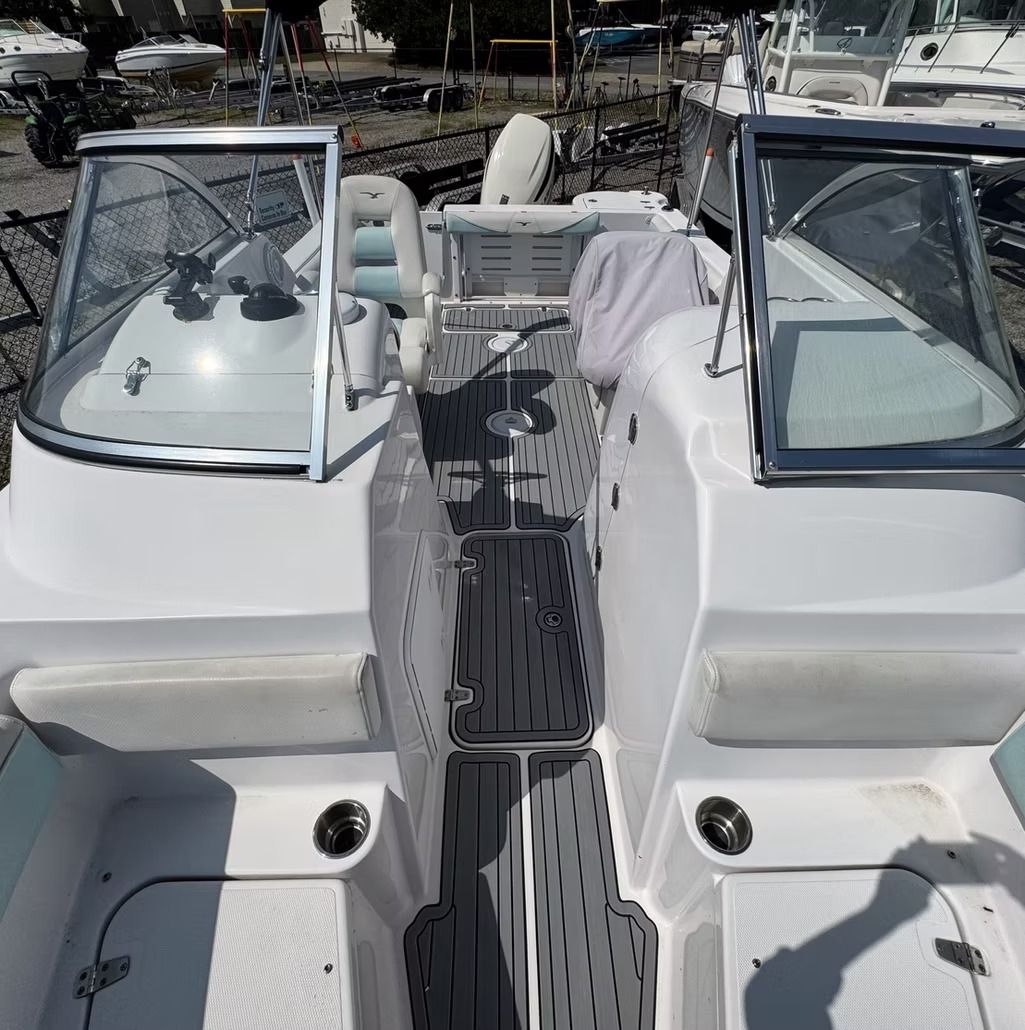 White motorboat interior with two windshields, center walkway, and boat seats.
