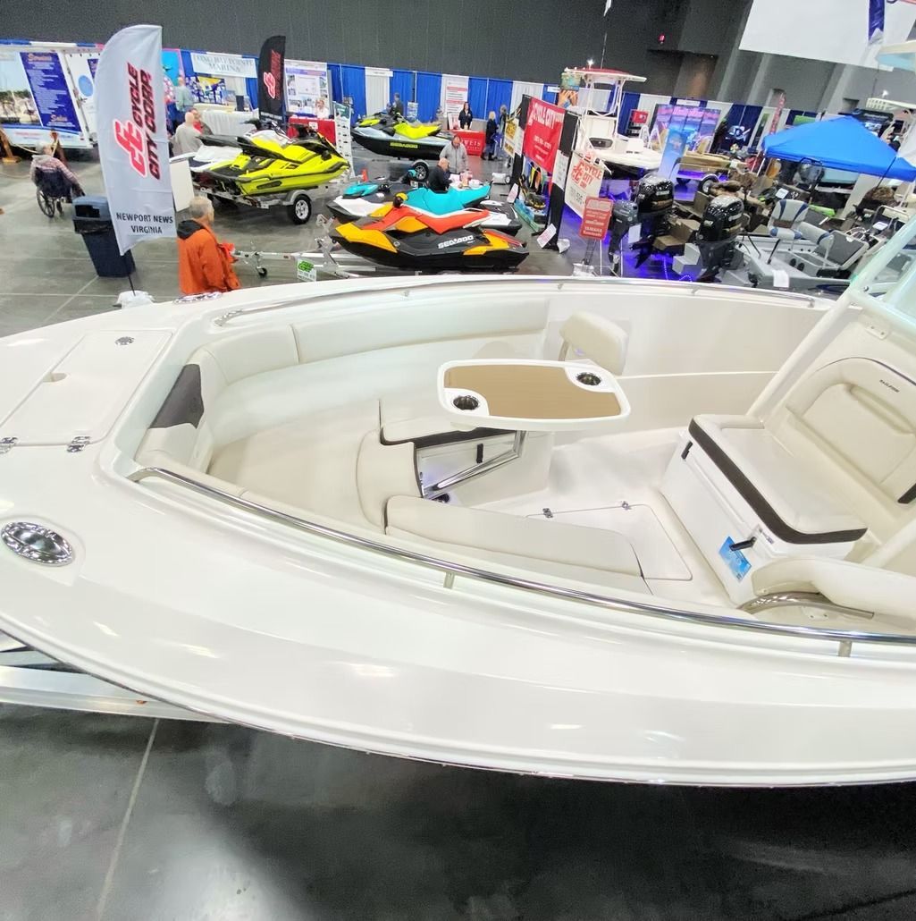 White boat interior at a boat show, surrounded by other watercraft.