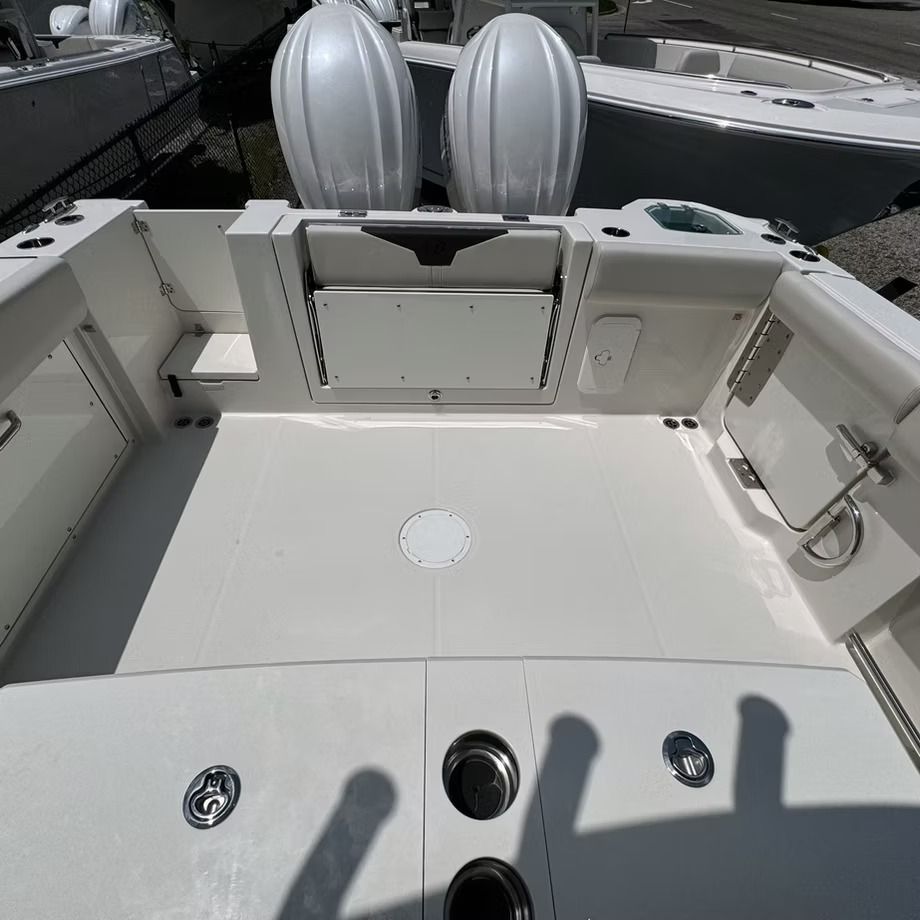 White boat deck with two outboard motors, cup holders, and storage compartments.