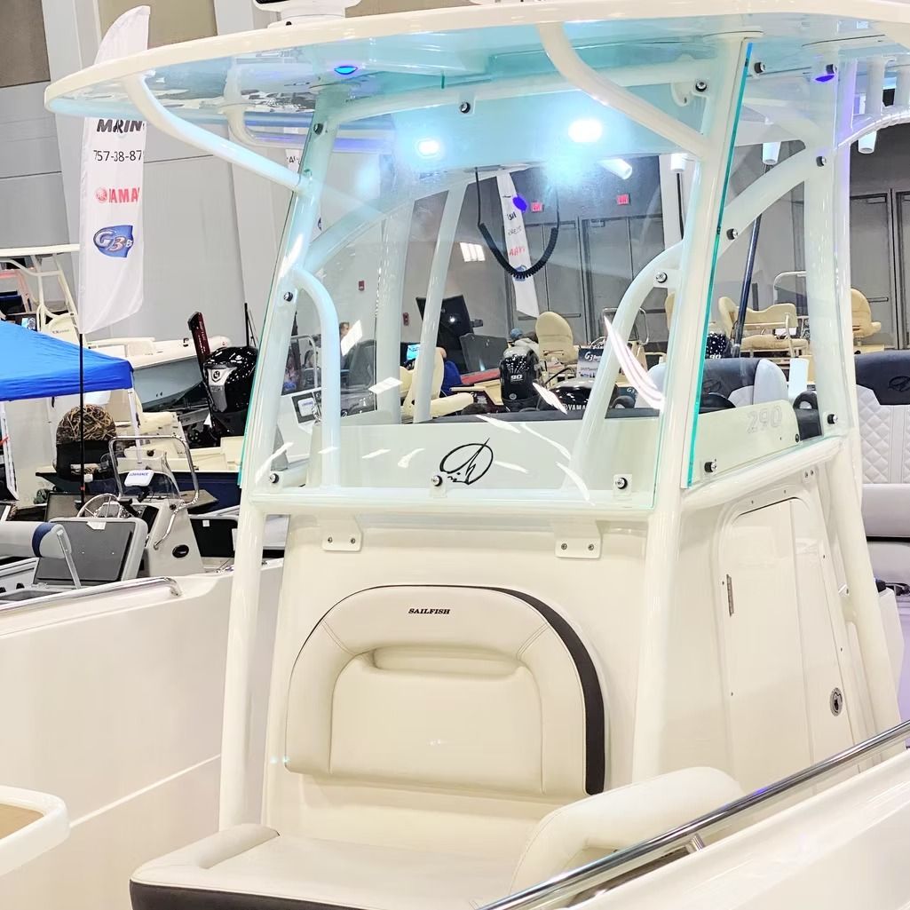 White boat with a T-top and clear windshield. Interior visible with seating and instruments.