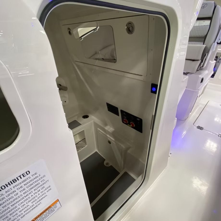 Open boat cabin interior with white walls, storage, and a small sink.