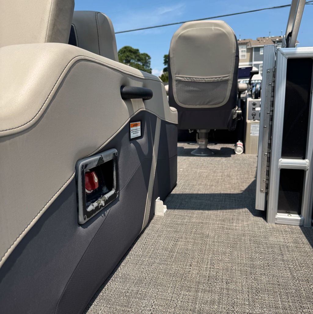 Tan and gray pontoon boat interior with seats, emergency shut off switch.