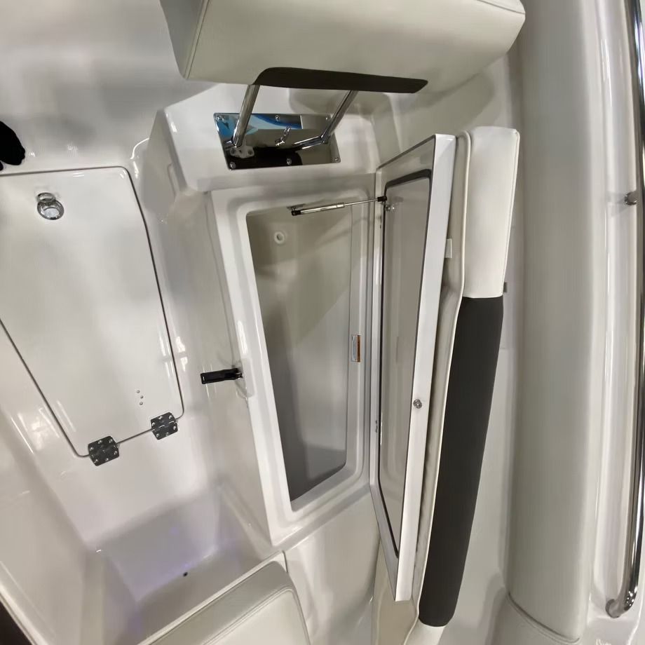 Boat interior with an open storage compartment, white with silver hinges and a black handle.