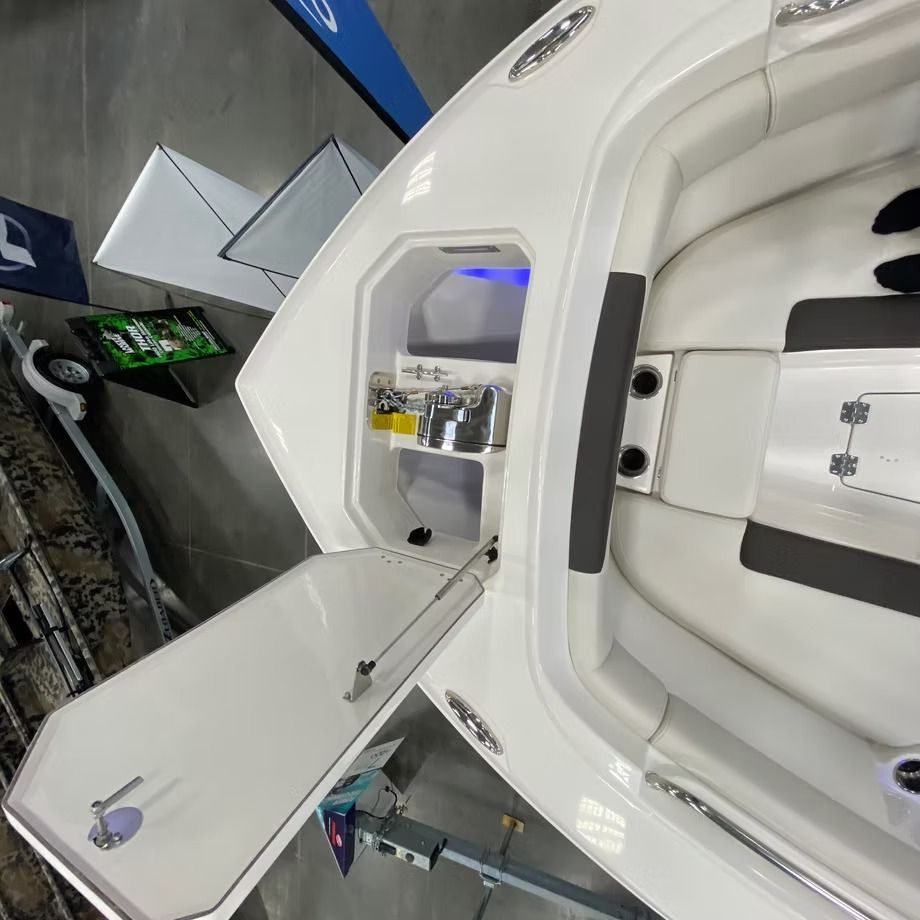 White boat with an open storage compartment revealing beverages and supplies.