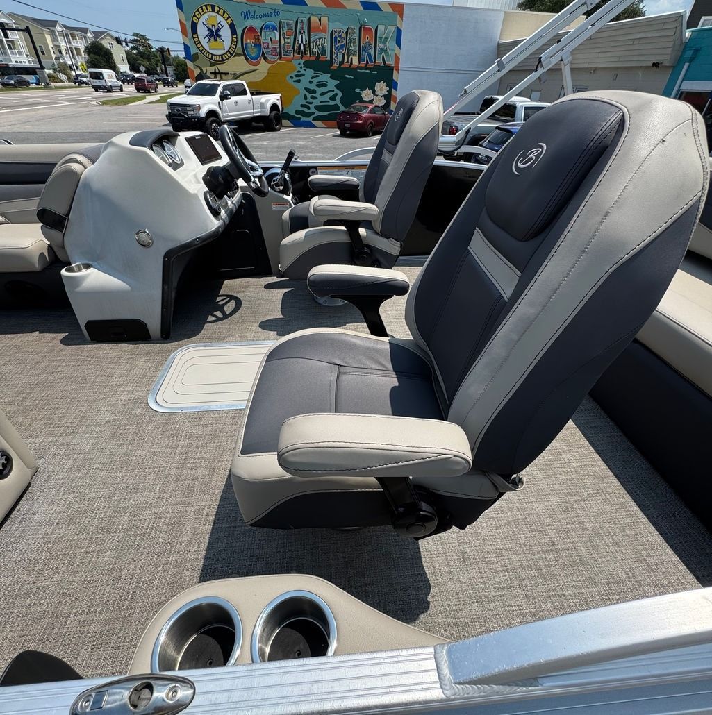 Pontoon boat interior with gray and tan seats.  Two cup holders are visible on the boat's edge.