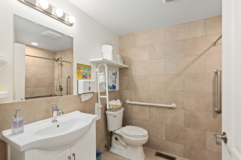 A bathroom with a toilet , sink and mirror.