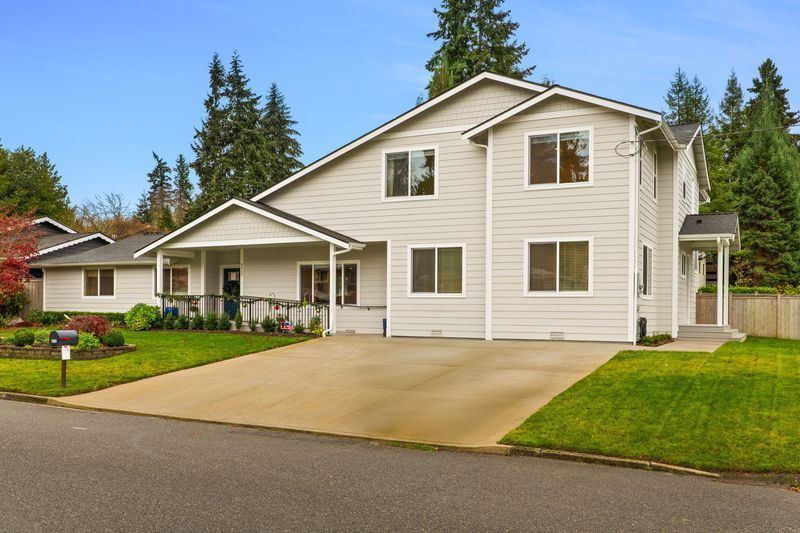 A large white house with a driveway in front of it.