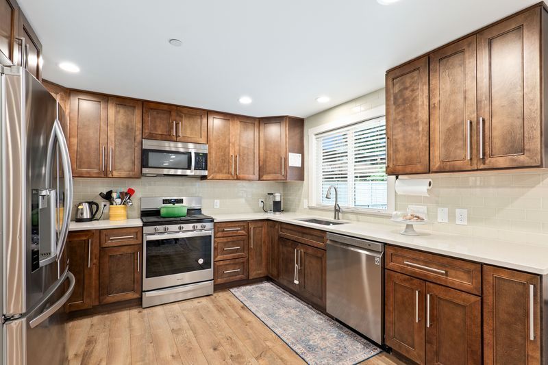 A kitchen with stainless steel appliances and wooden cabinets.