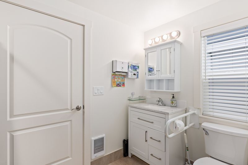 A bathroom with a sink , toilet and window.