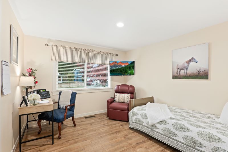 A bedroom with a bed , chair , desk and television.