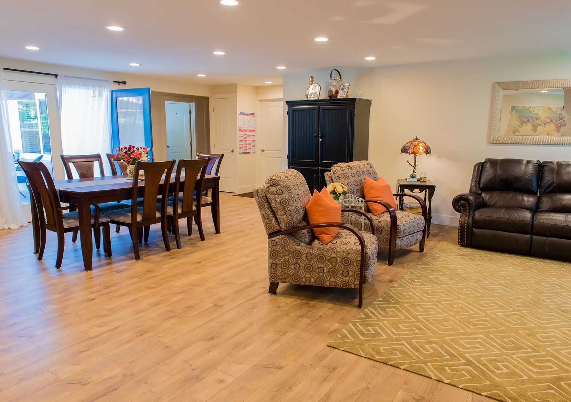 A living room with a couch , chairs , a table and a rug.