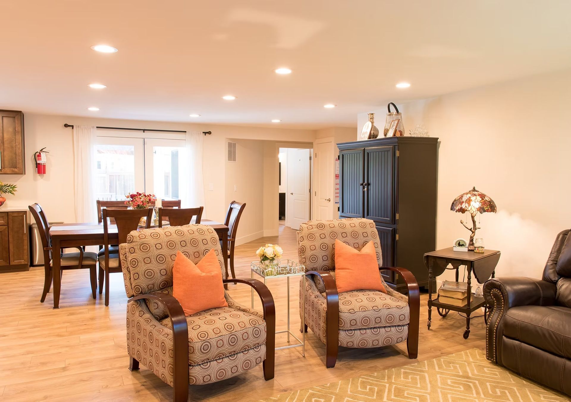 A living room with two chairs , a couch , a table and a lamp.