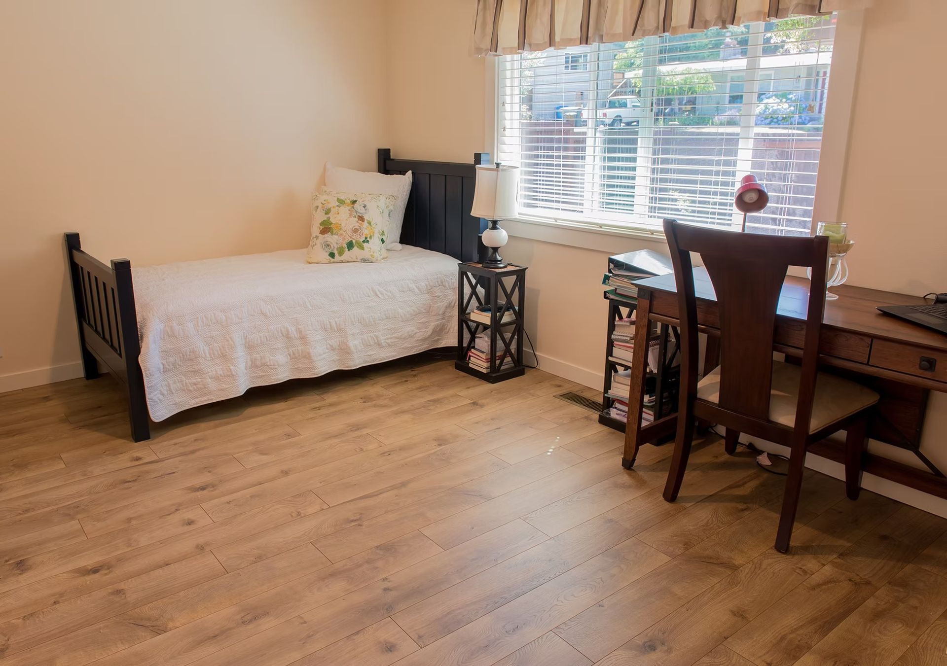 A bedroom with a single bed , desk , chair and window.
