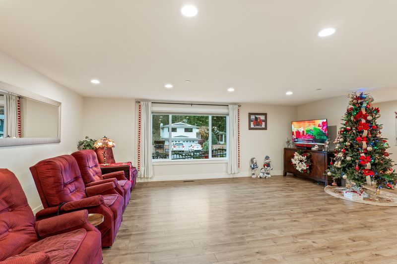 There is a christmas tree in the middle of the living room.