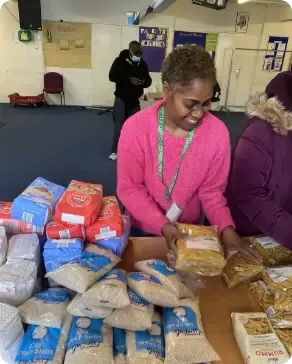 A woman in a pink sweater is putting food on a table