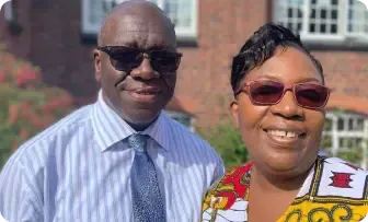 A man and a woman wearing sunglasses are posing for a picture.