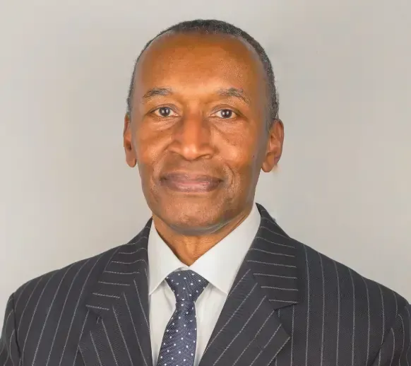 A man in a suit and tie is smiling for the camera