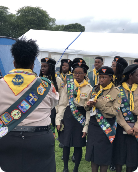 A group of girl scouts are standing in a field