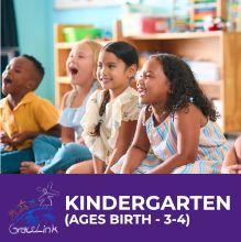 A group of children are sitting on the floor in a classroom.