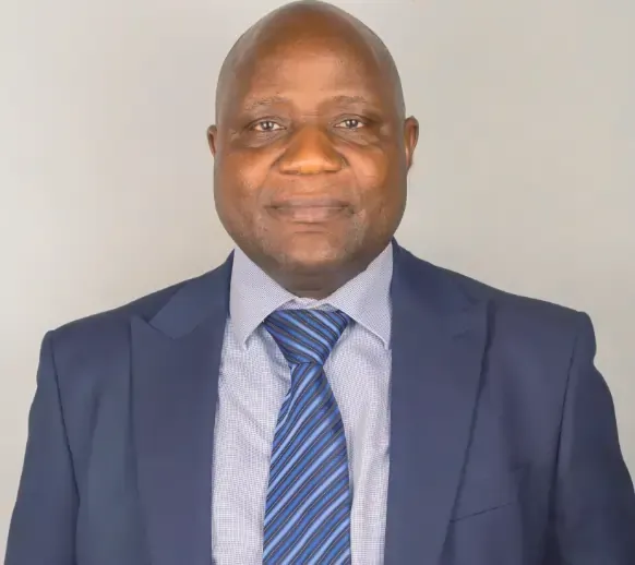 A man in a suit and tie is smiling for the camera.