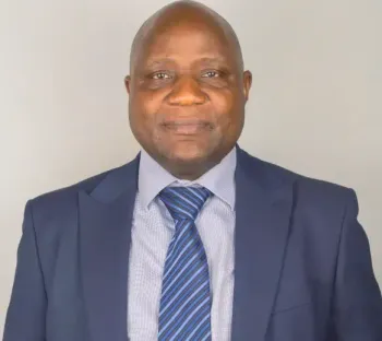 A man in a suit and tie is smiling for the camera.