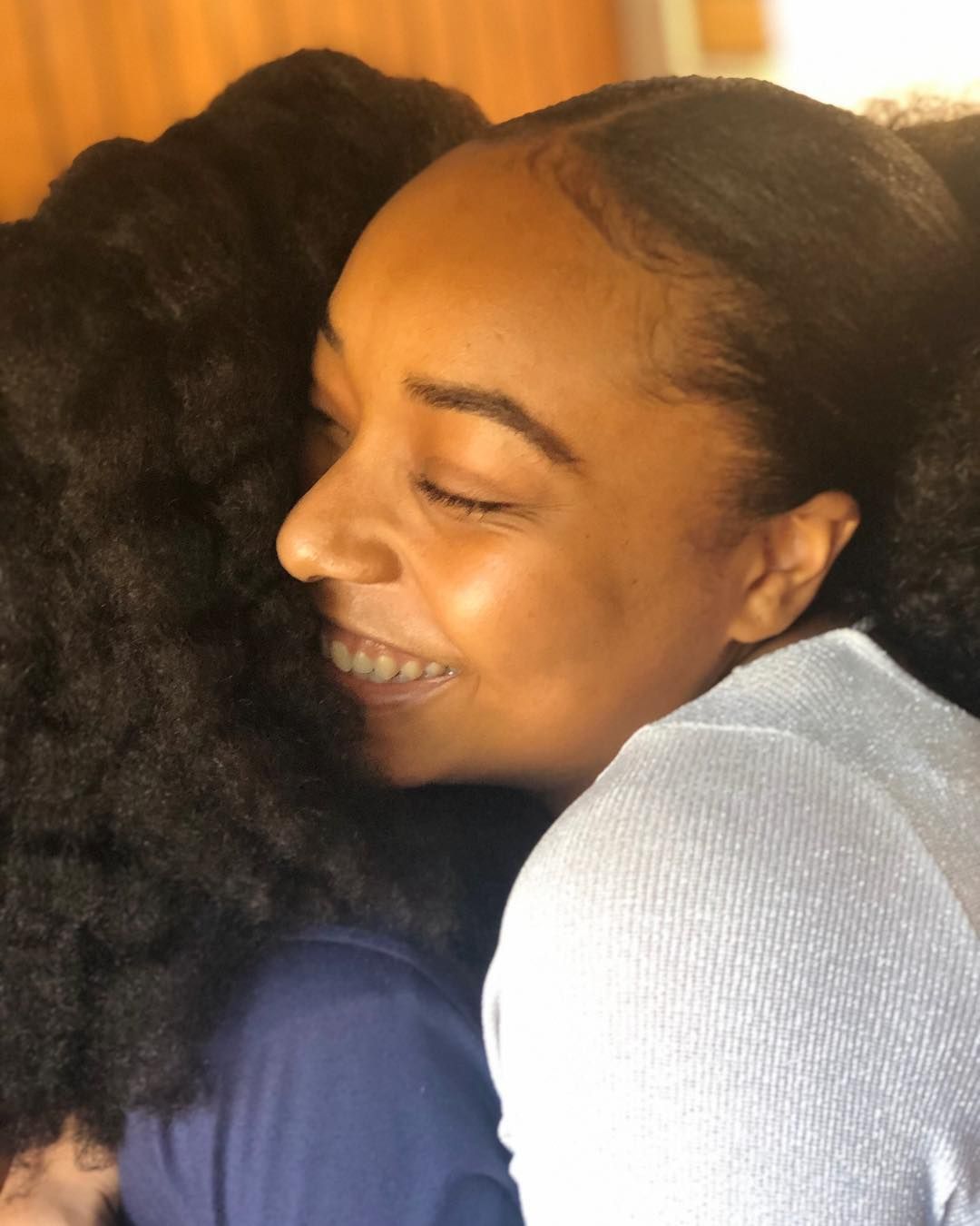 A woman hugging another woman with her eyes closed