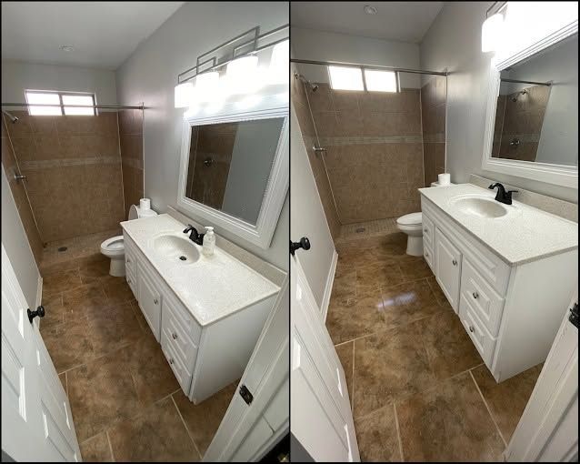 Small bathroom with white vanity, mirror, toilet, and tan tiled shower walls.