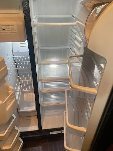 Open refrigerator with mostly empty shelves and a few items in the door bins
