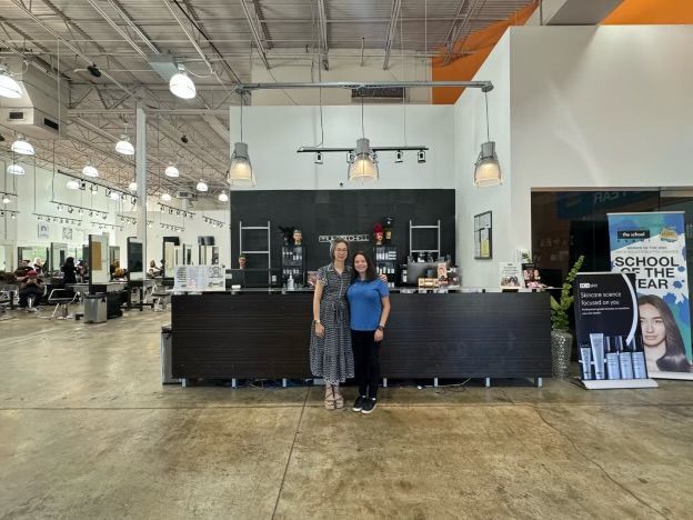 Two women are standing in front of a counter in a salon.