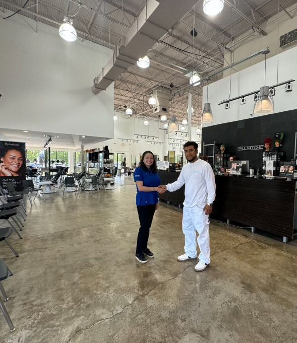 A man and a woman are shaking hands in a salon.