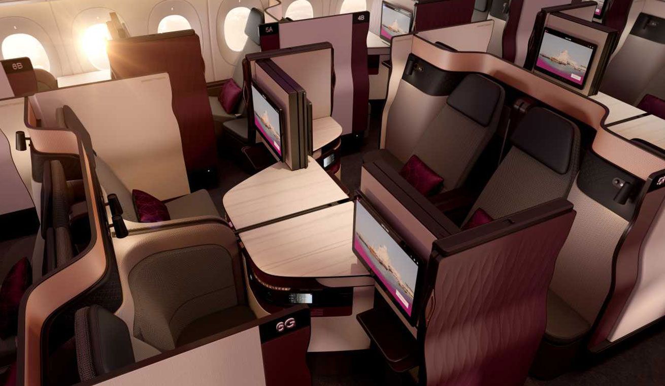 Qatar Airways Qsuite Business Class cabin with lie-flat seats and privacy doors, bookable from the UK with xLuxuryFlights.com
