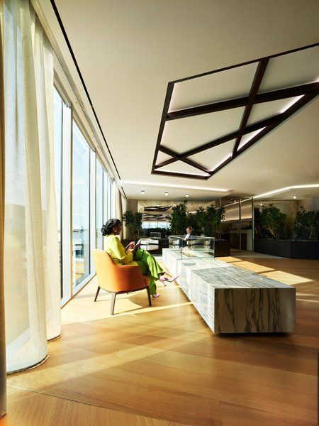 A woman is sitting in an orange chair in a living room