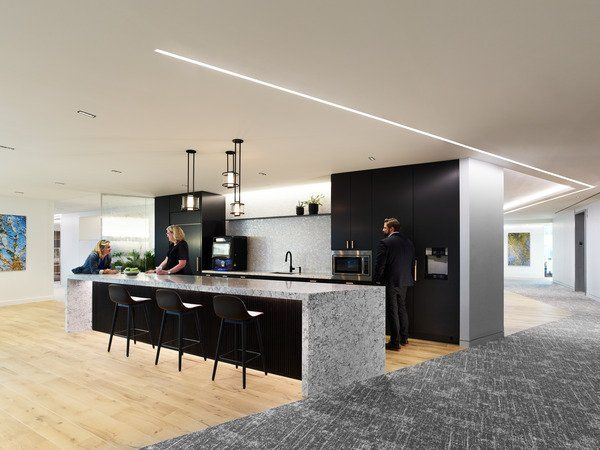 A group of people are standing around a kitchen counter.