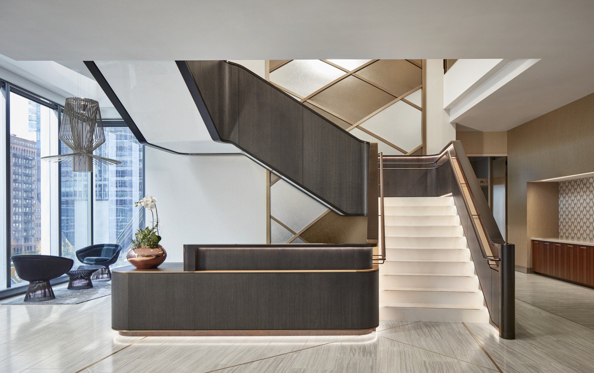 A lobby with a staircase and a reception desk.