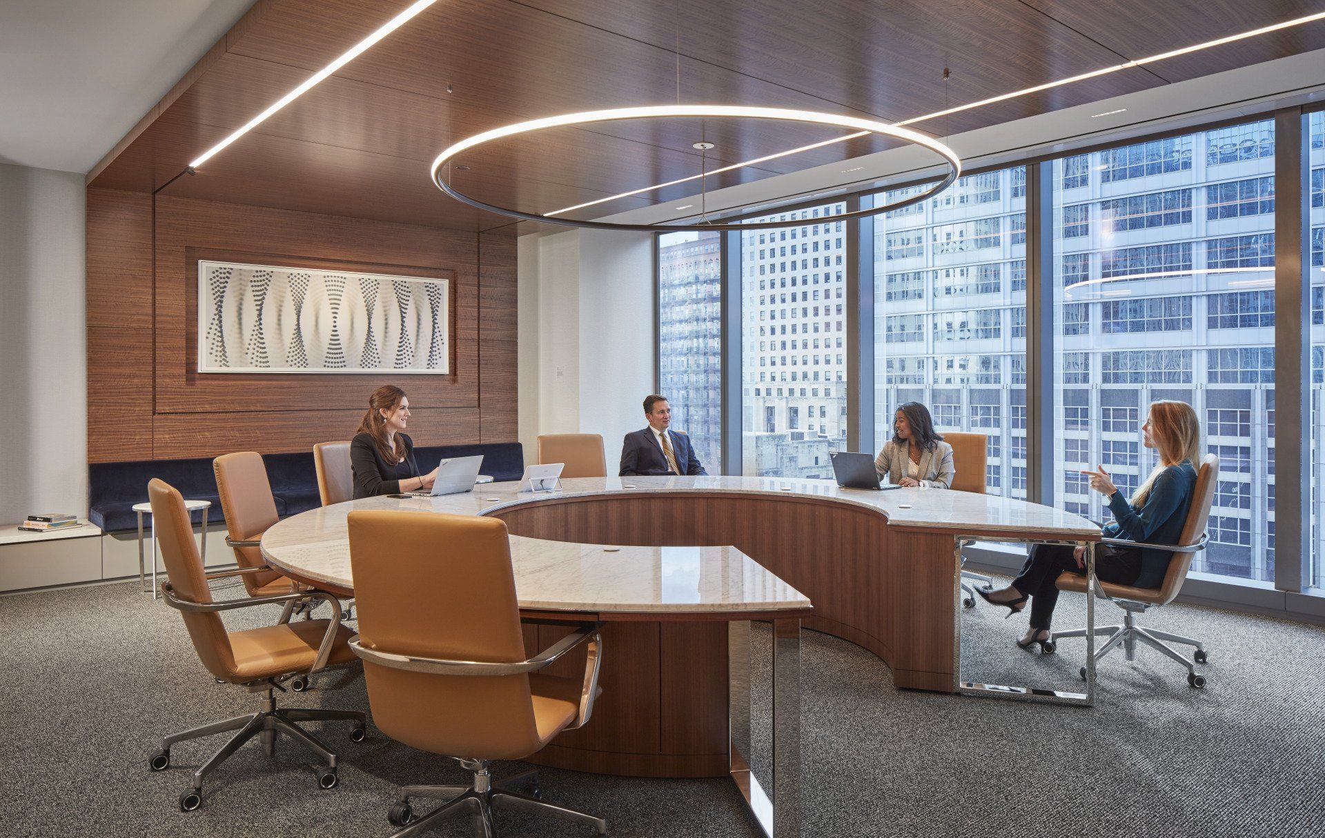 A group of people are sitting around a round table in a conference room.