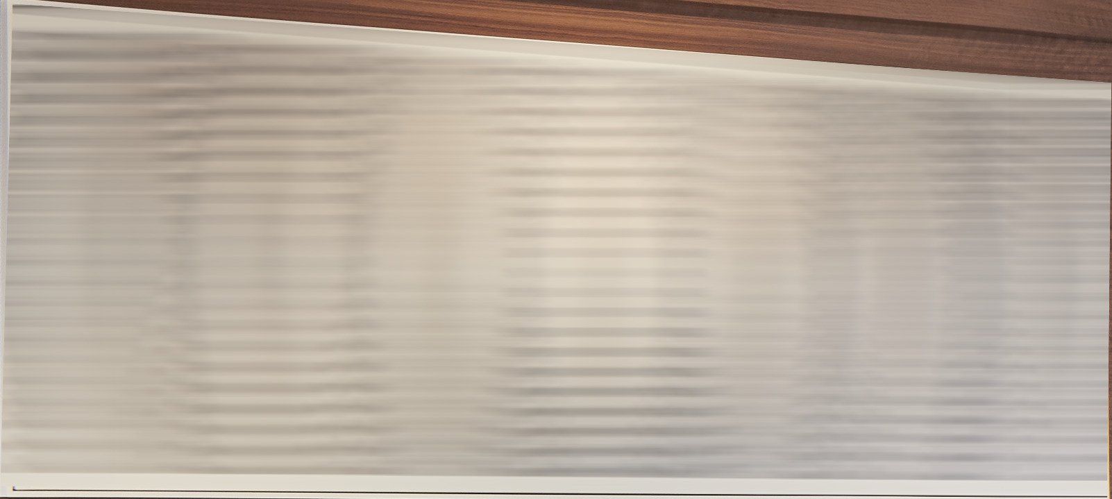A close up of a white blind on a window.