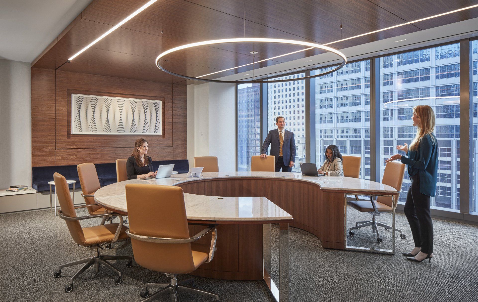 A group of people are standing around a round table in a conference room.