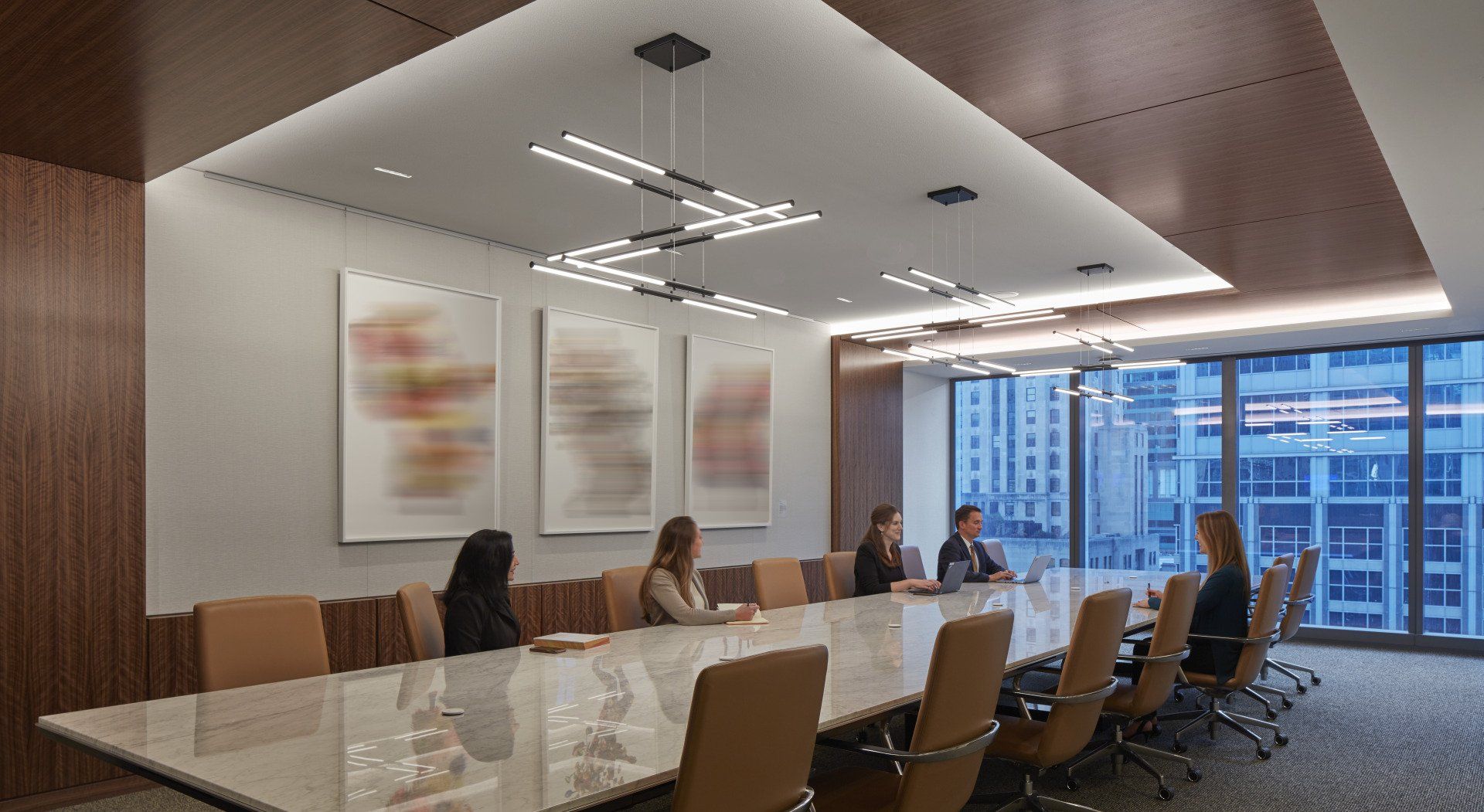 A group of people are sitting at a long table in a conference room.