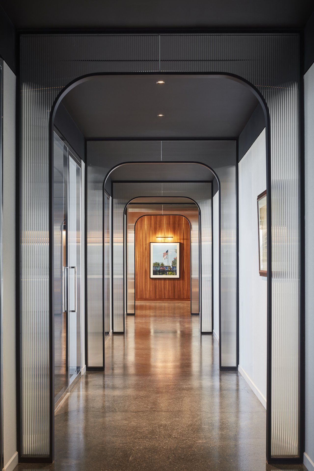 A long hallway in a building with a picture on the wall.
