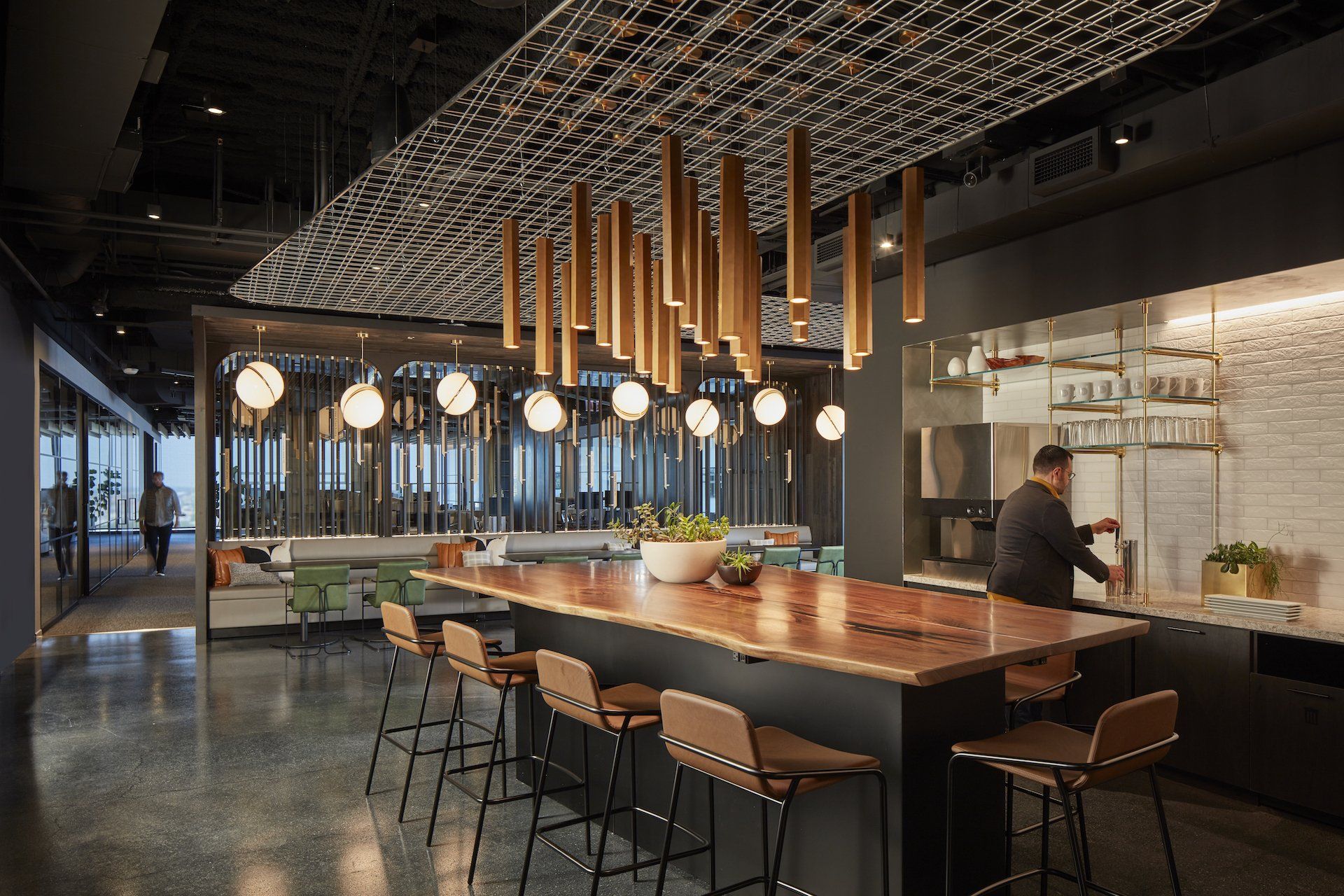 A man is standing at a long table in a kitchen.