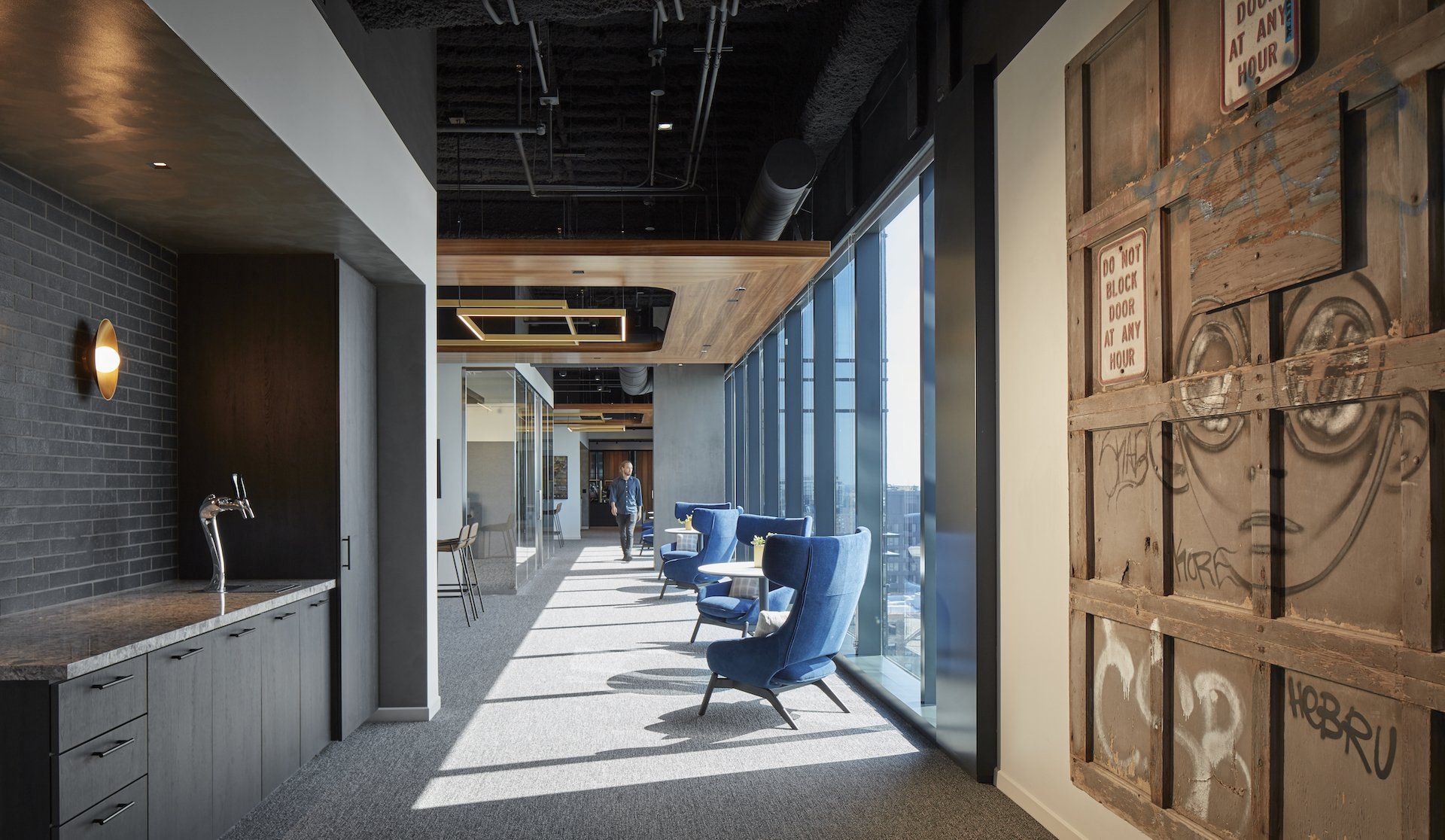 A long hallway with a lot of windows and chairs.