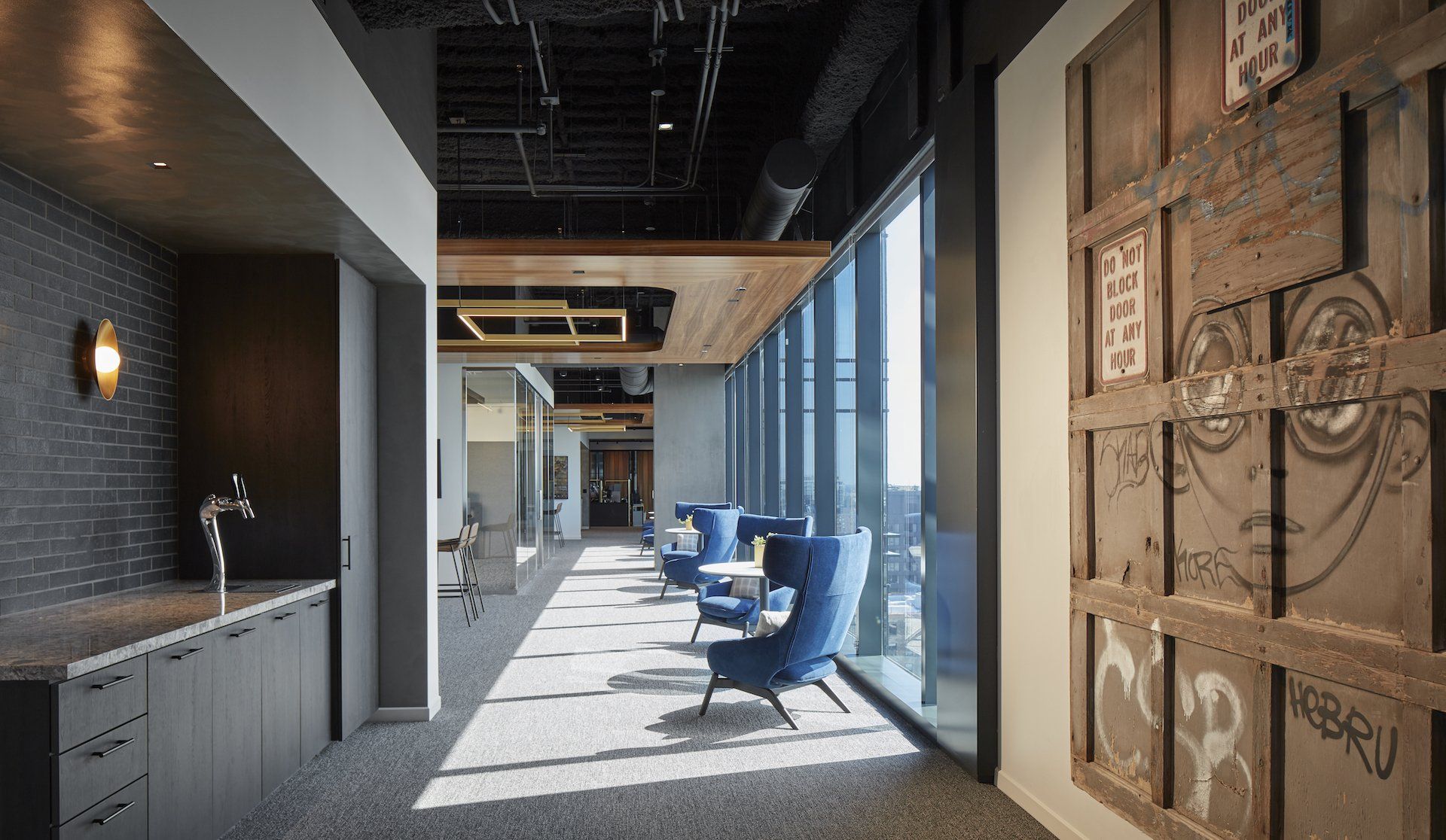 A long hallway with a lot of windows and chairs.