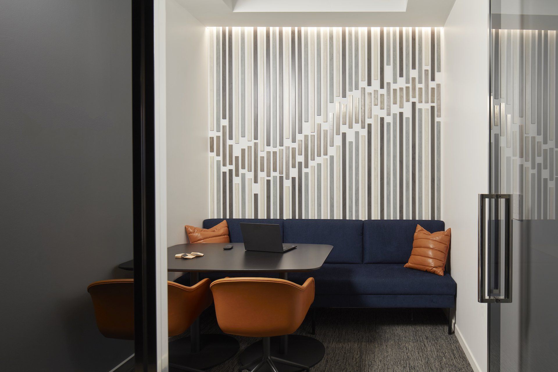 A conference room with a blue couch , table and chairs.
