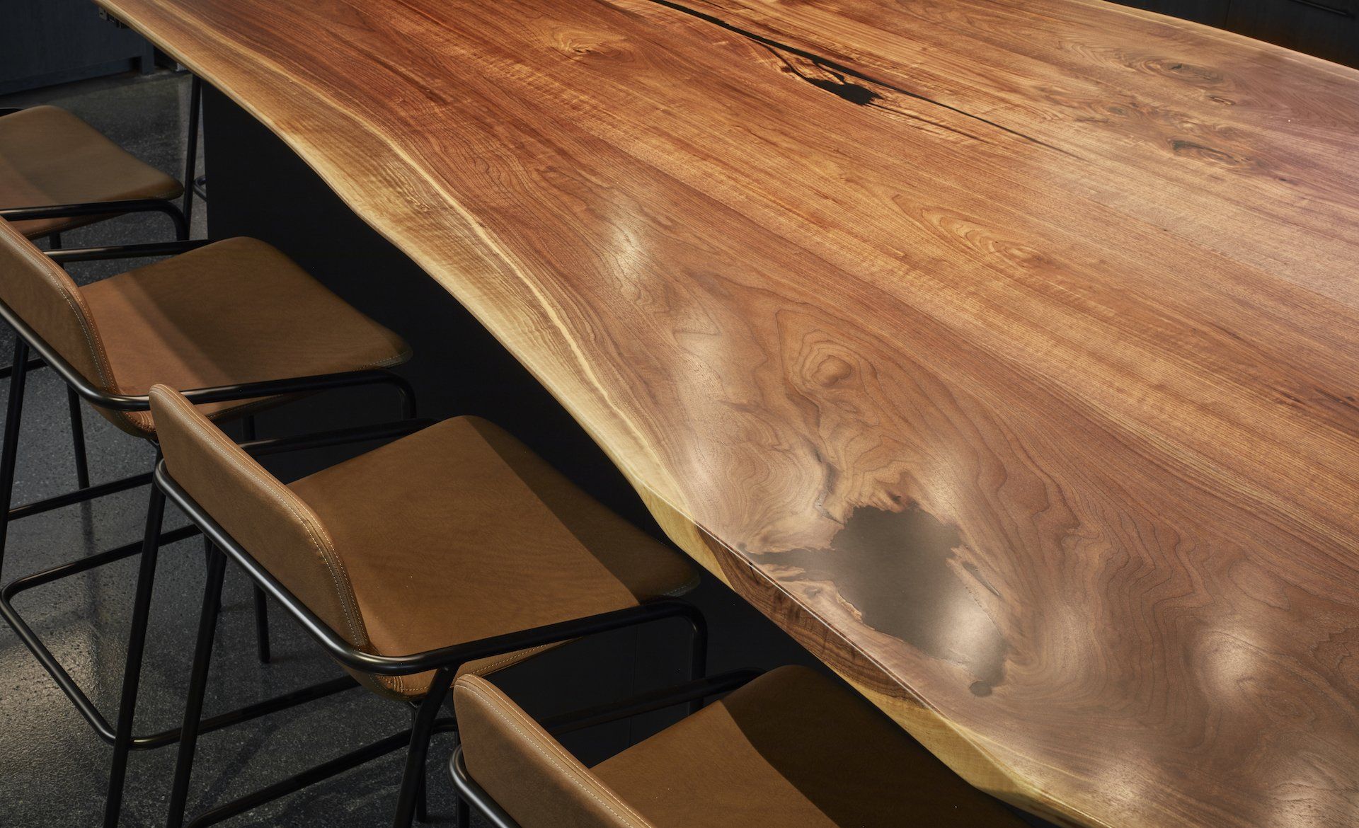 A wooden table with stools underneath it in a room.