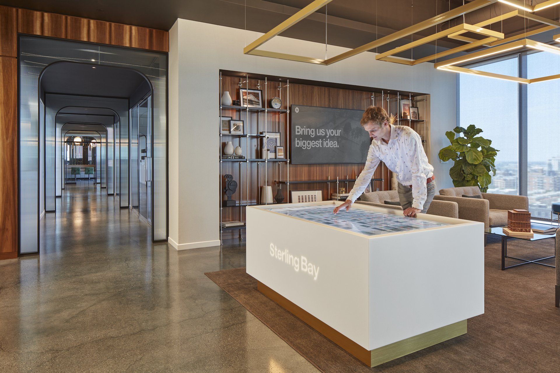 A man is standing at a table in a living room looking at a map.