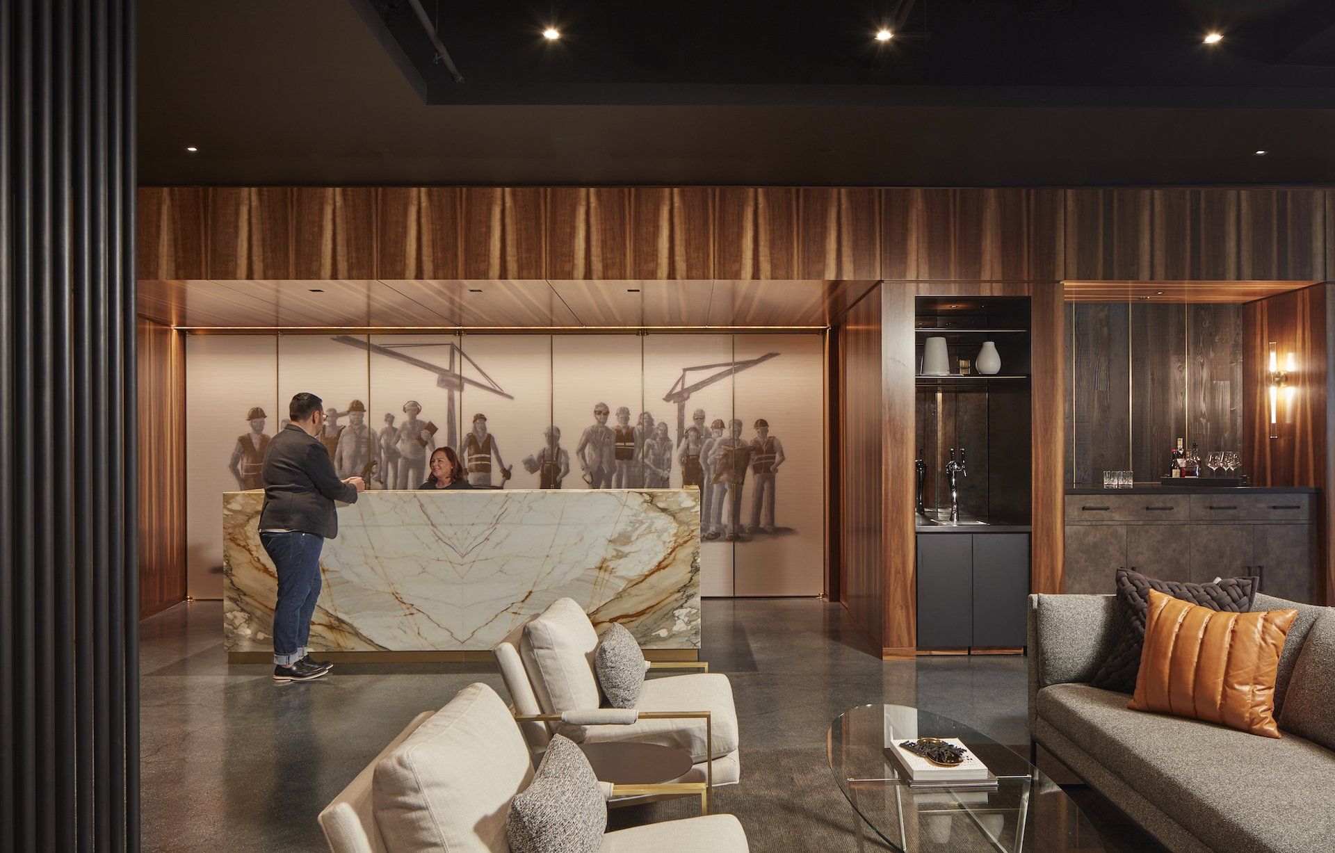 A man is standing at a reception desk in a lobby.