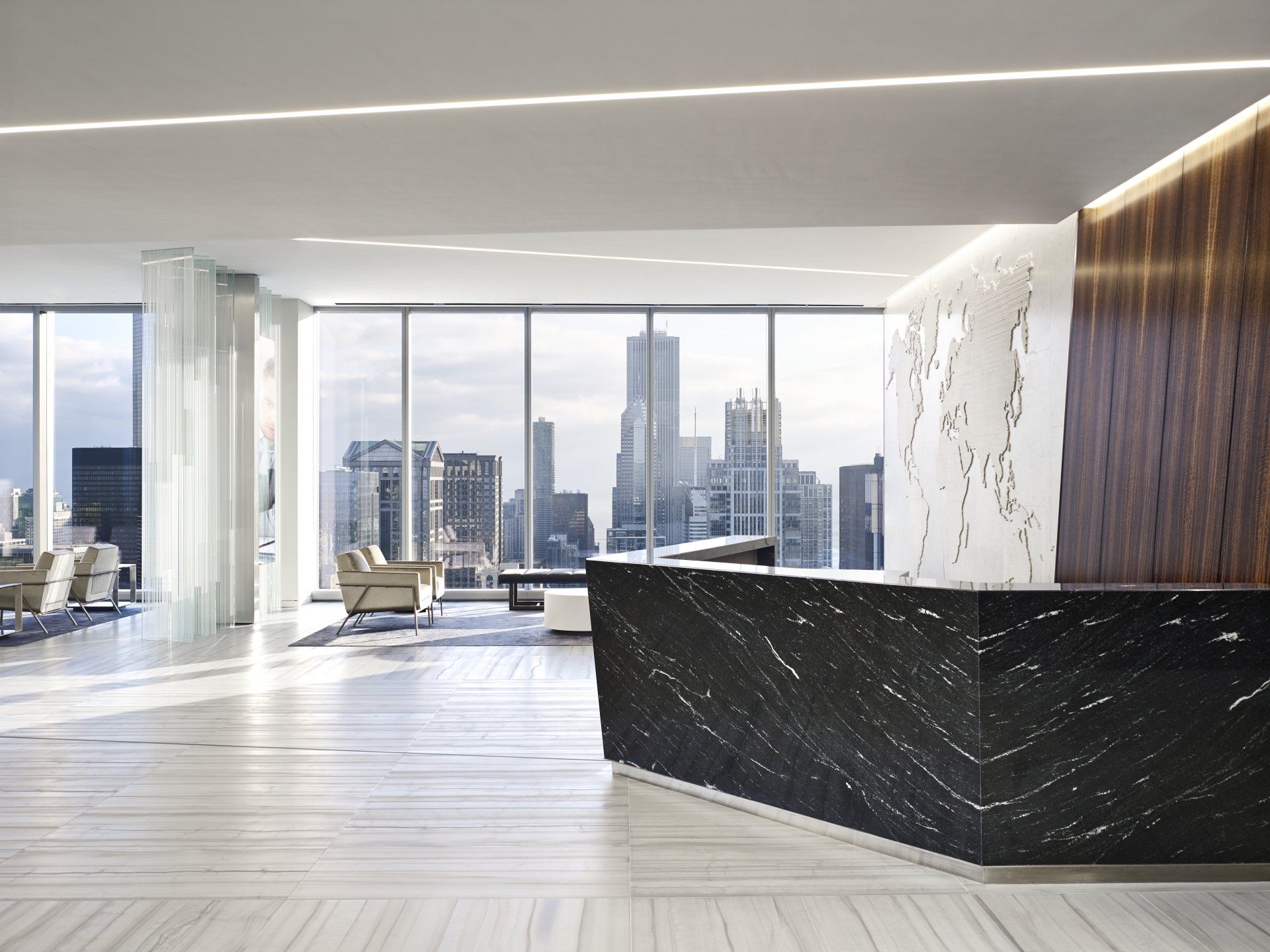A lobby with a large black counter and a view of the city.