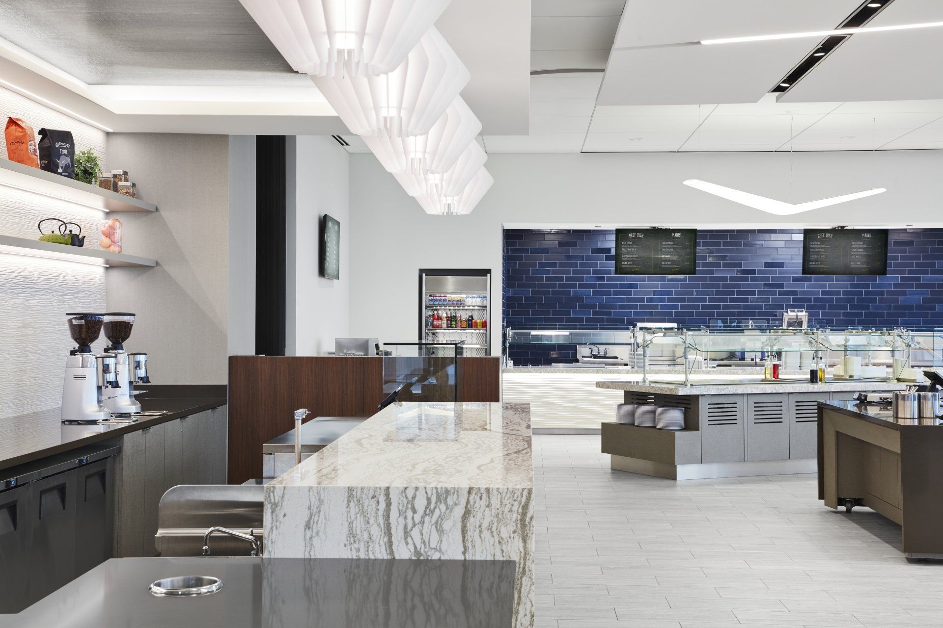 A kitchen with a blue brick wall and white counter tops